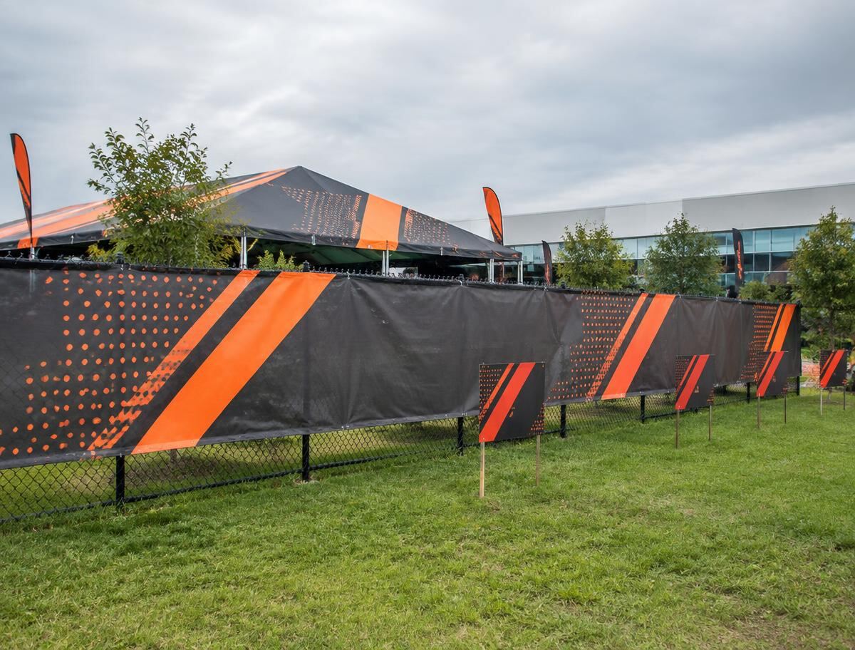 Branded vinyl fence banners and coordinating yard signs at an outdoor activation
