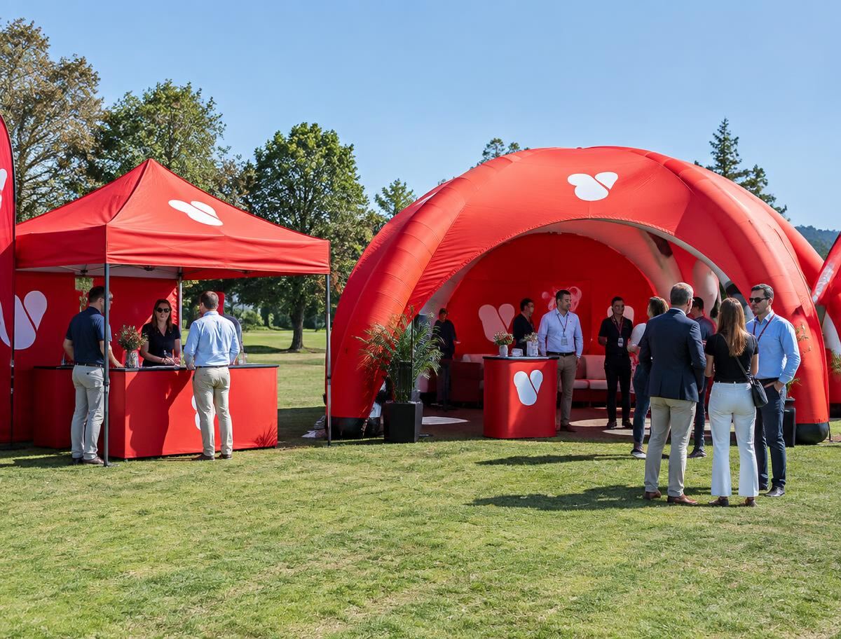 Branded pop-up canopy tent and inflatable air-frame tent at an outdoor corporate event