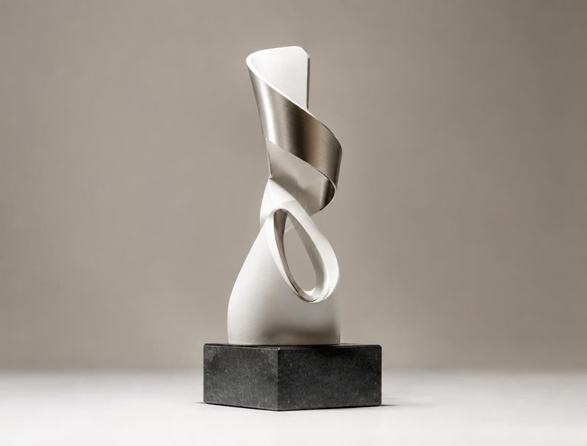 Sculptural custom 3D-printed award in white and brushed metal on a stone base
